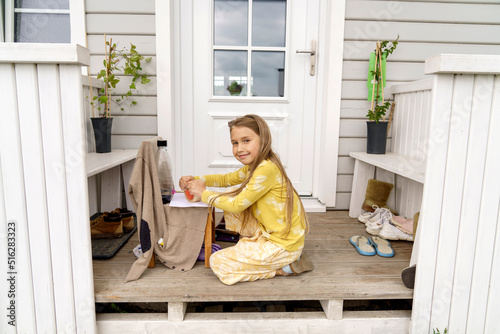 Smiling girl playing at entrance of house photo