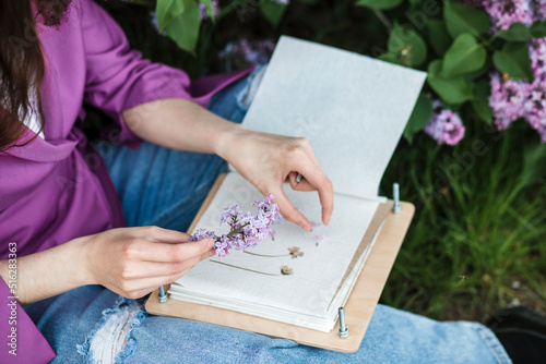Woman sitting with lilac flower and book photo