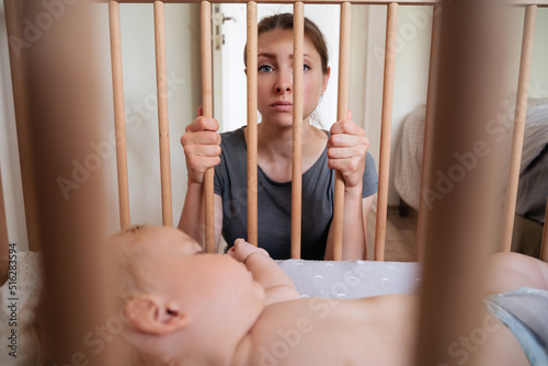 Fotografija Young frustrated mother feels imprison while takes care of her infant and suffering from postnatal depression