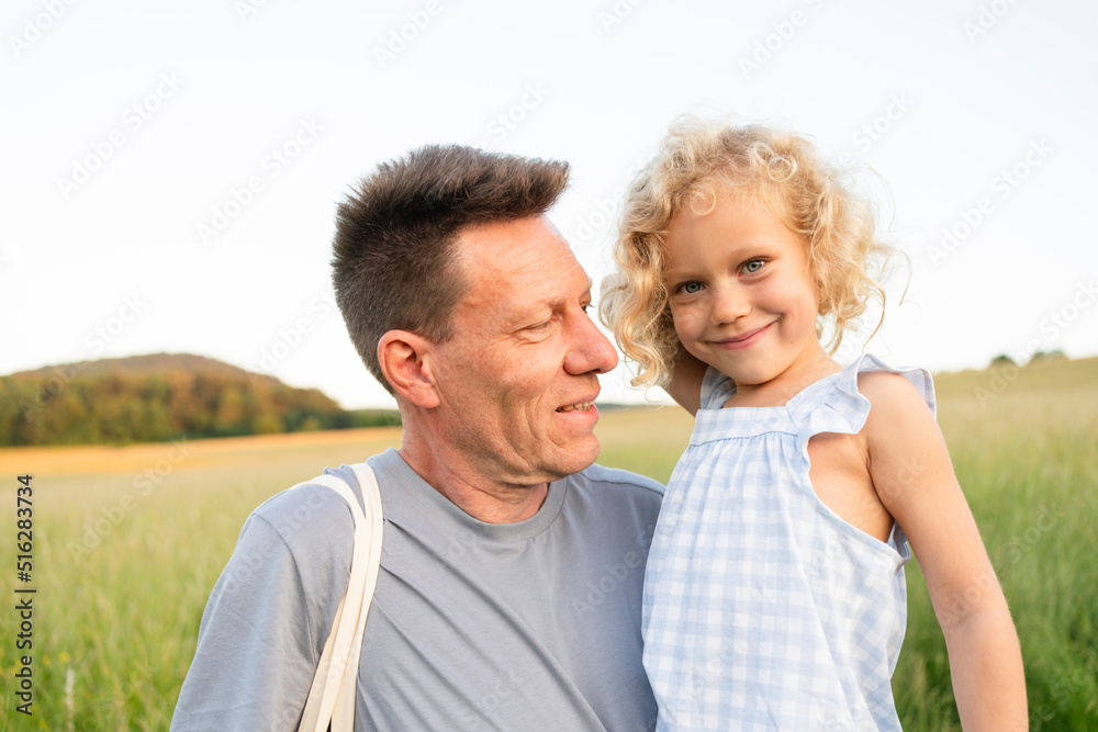 Smiling father looking at blond daughter Smiling father looking at blond daughter