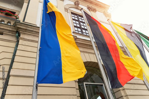 Big Ukraine Germany and Saxony Anhalt flags waving blowing by wing on Magdeburg city hall building facade. Ukrainian and Germany partnership, support and friendship concept