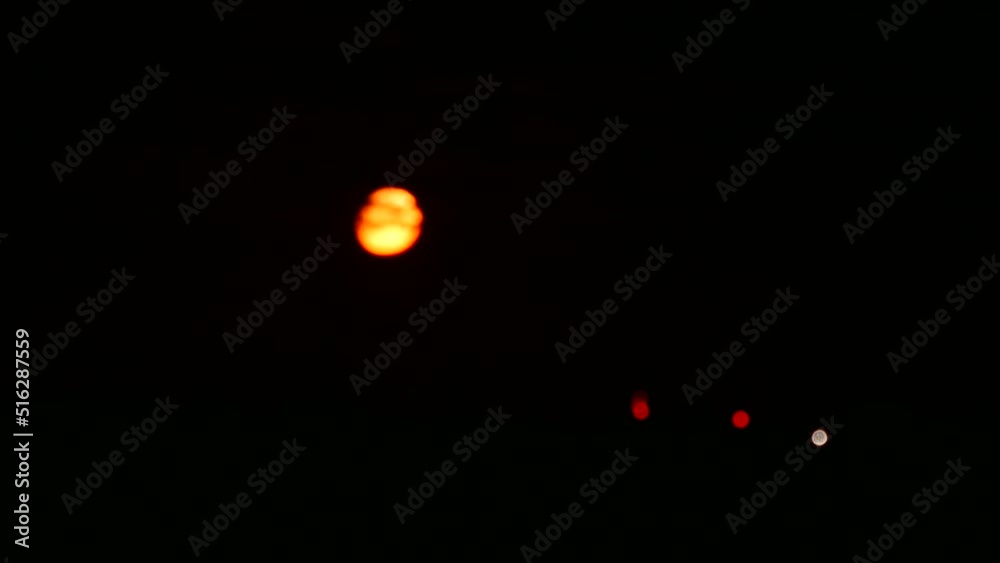 Defocused falling golden and red waxing gibbous moon time lapse Defocused falling golden and red waxing gibbous moon time lapse