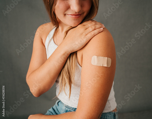 Εκτύπωση καμβά Close up female sitting and looking at the band aid on her arm