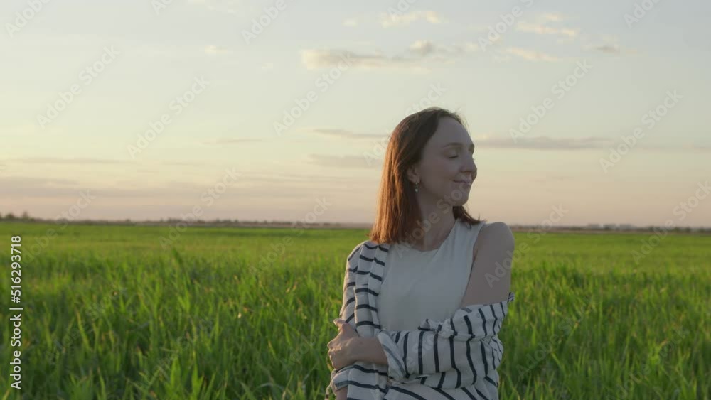 4K. Happy young woman posing at sunset in a field. 4K. Happy young woman posing at sunset in a field.