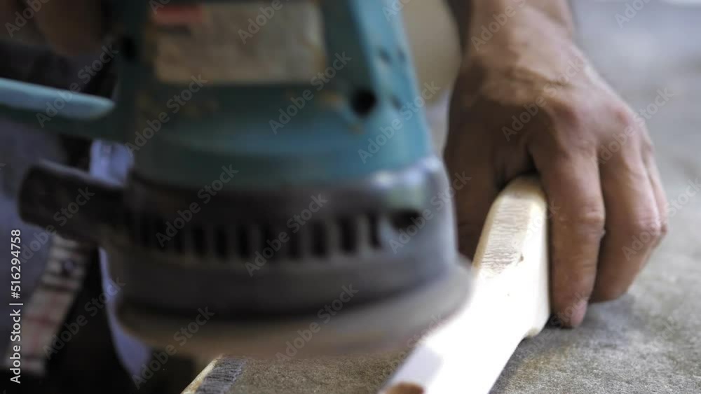 A professional carpenter working with wood on a woodworking machine grinds and polishes wood.Wooden products.Handmade furniture.Manufactures furniture parts in natural light.Carpentry tools