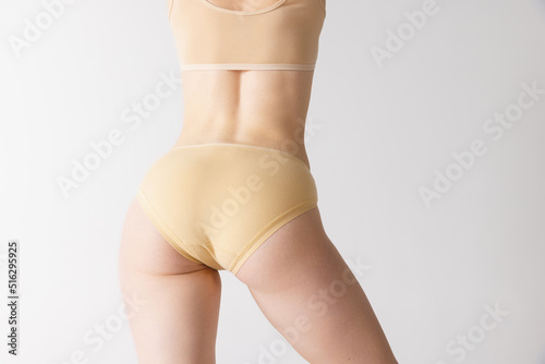Sportive female body, buttocks in panties, underwear isolated over gray studio background. Concept of fitness, diet, bodycare, health, beauty, ad