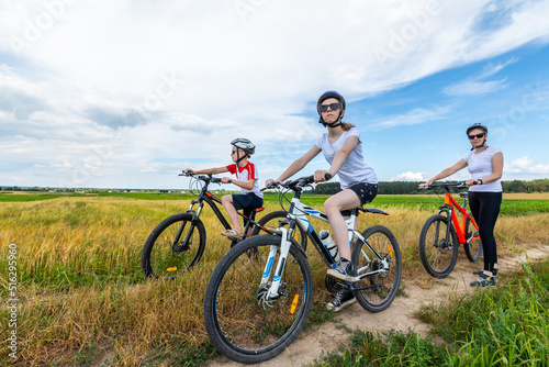 Happy mother and kids on bikes cycling outdoors. active family sport and fitness together. happy family on bike ride outdoors.