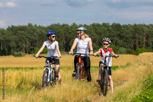 Happy mother and kids on bikes cycling outdoors. active family sport and fitness together. happy family on bike ride outdoors.