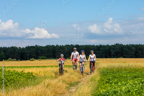 happy family on bike ride outdoors. Happy mother father and kids on bikes cycling outdoors. active family sport and fitness together © drotik