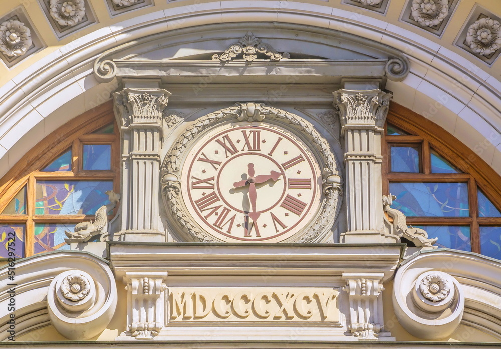 Antique clock chimes decorated with stucco on the facade of the building