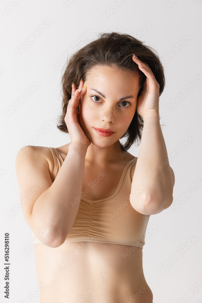 Young pretty woman with well-kept skin without makeup isolated on white studio background. Spa, cosmetics, face lifting and skin care concept Young pretty woman with well-kept skin without makeup isolated on white studio background. Spa, cosmetics, face lifting and skin care concept