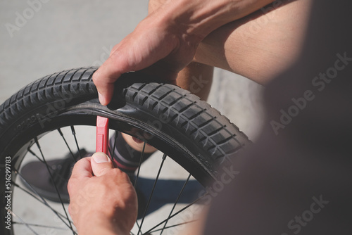 cyclist removes a tire from a bicycle wheel by tire lever close-up