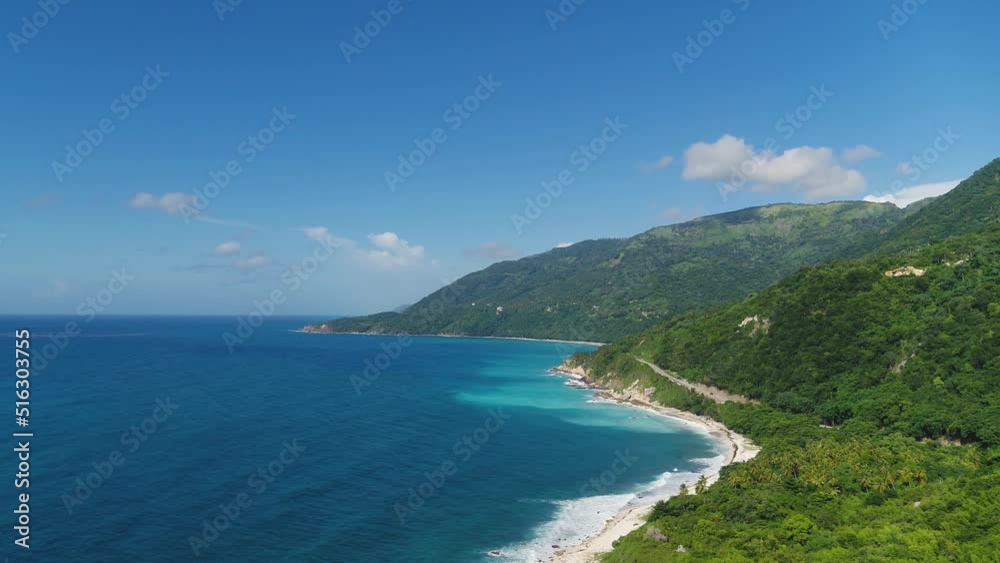 Beach coastline of the Atlantic off a tropical peninsula. High green mountains against a blue sky with white clouds. Beautiful wild nature of Latin America. Beach coastline of the Atlantic off a tropical peninsula. High green mountains against a blue sky with white clouds. Beautiful wild nature of Latin America.