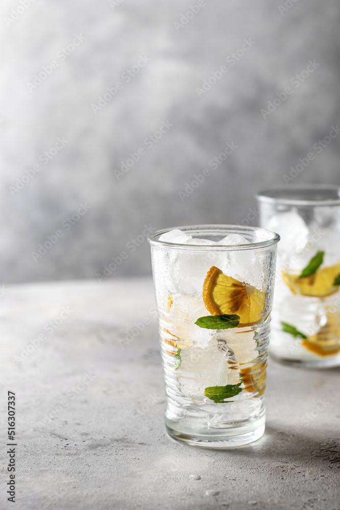Iced cold lemon mint summer cocktail on gray background with text space on the left Iced cold lemon mint summer cocktail on gray background with text space on the left
