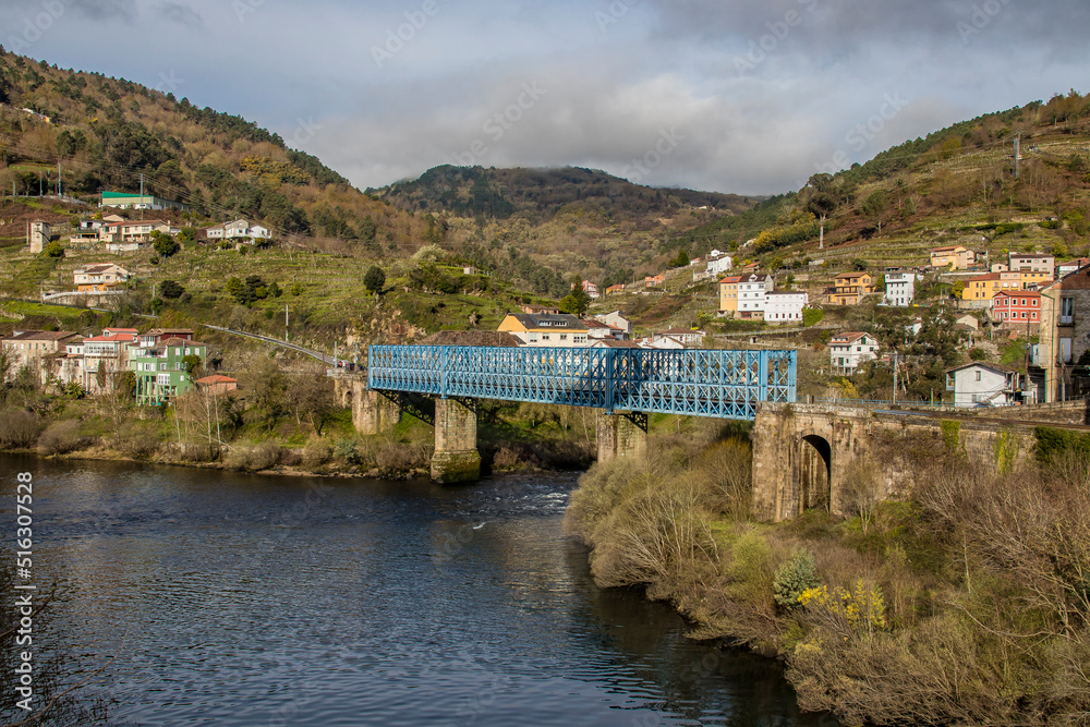 Panoramic view of the town of Os Peares, its blue train bridge and the Miño river. Ourense. Galicia. Ribeira Sacra