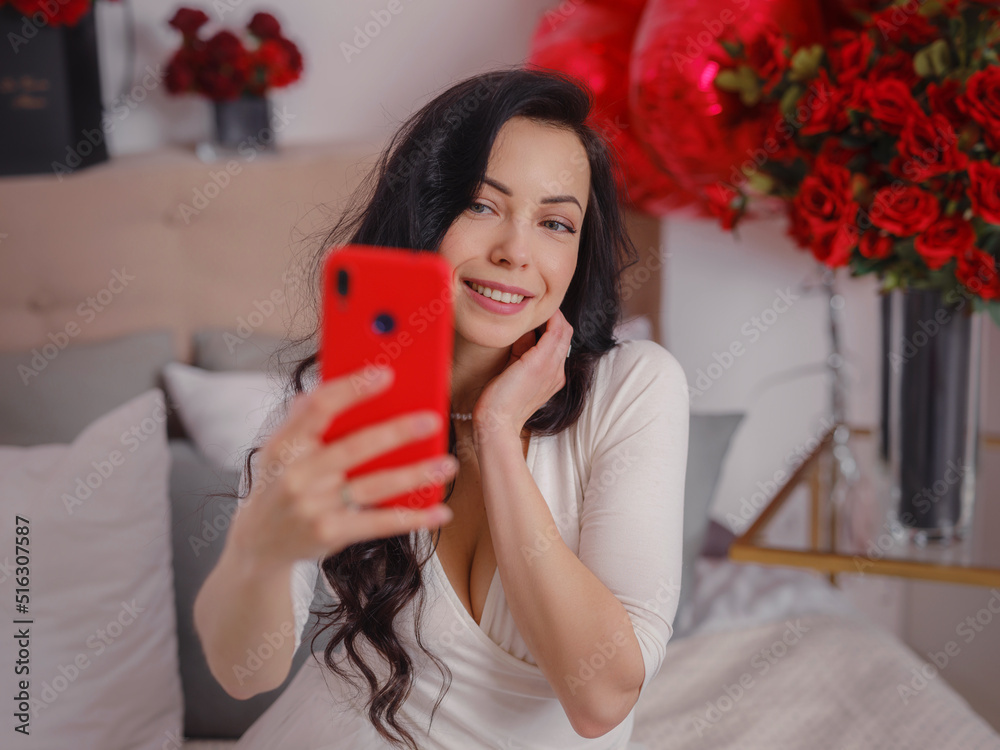 young woman in white dres taking selfie with smartphone and sitting on bed. morning love bedroom. Anniversary, happy birthday, wedding , love day, women's day, Valentine day and positive emotions young woman in white dres taking selfie with smartphone and sitting on bed. morning love bedroom. Anniversary, happy birthday, wedding , love day, women's day, Valentine day and positive emotions