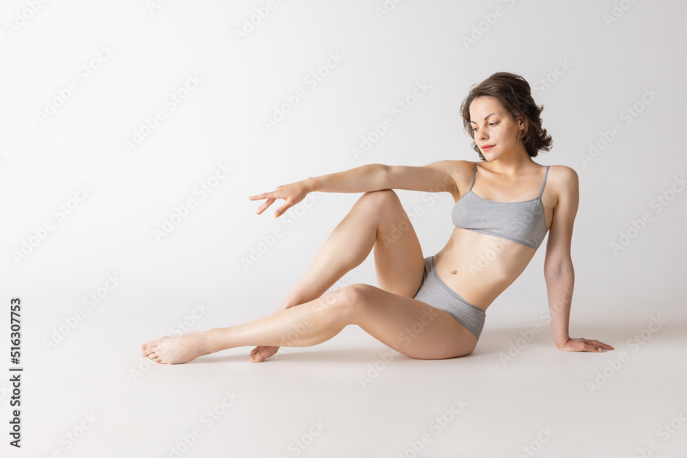Studio shot of fit adorable woman in comfortable cotton underwear isolated over grey studio background Studio shot of fit adorable woman in comfortable cotton underwear isolated over grey studio background