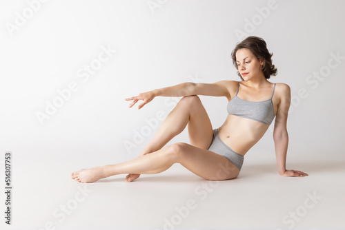 Studio shot of fit adorable woman in comfortable cotton underwear isolated over grey studio background © master1305