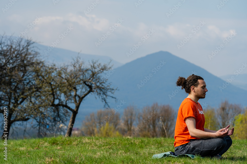 Young man do yoga on the rock peak. Meditation