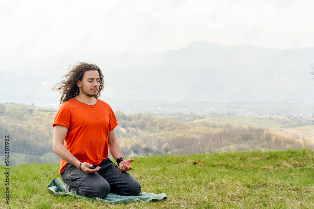 Young man meditating yoga on the mountain. Relax and calm