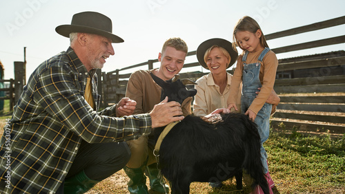 Принти на полотні Grandparents and grandchildren caress goat on farm
