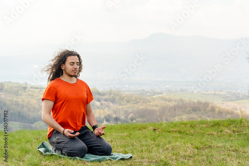 Young man meditating yoga on the mountain. Relax and calm