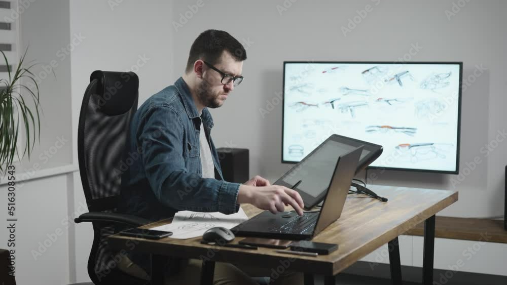 Industrial design studio with graphic tablet and computers. A senior designer draws a new car concept on a tablet. Industrial design studio with graphic tablet and computers. A senior designer draws a new car concept on a tablet.
