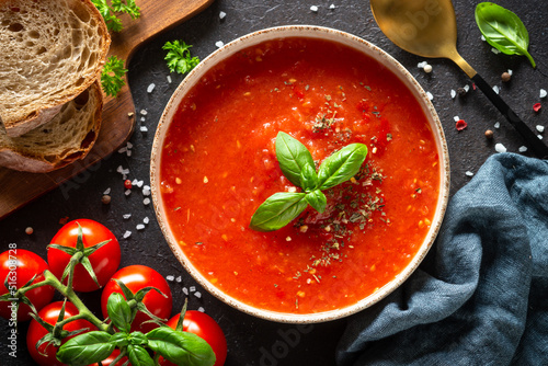 Tomato soup with ingredients on dark background. Traditional vegetable soup. Top view.