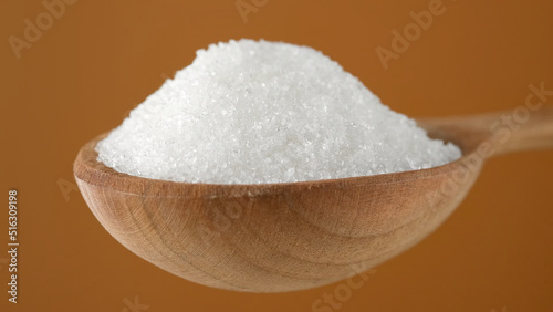 White powder sugar in wooden spoon. 