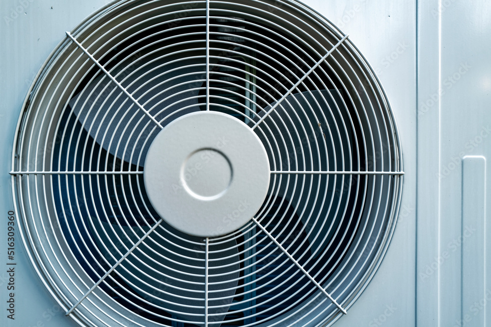 An air conditioner compressor fan mounted on an exterior wall An air conditioner compressor fan mounted on an exterior wall