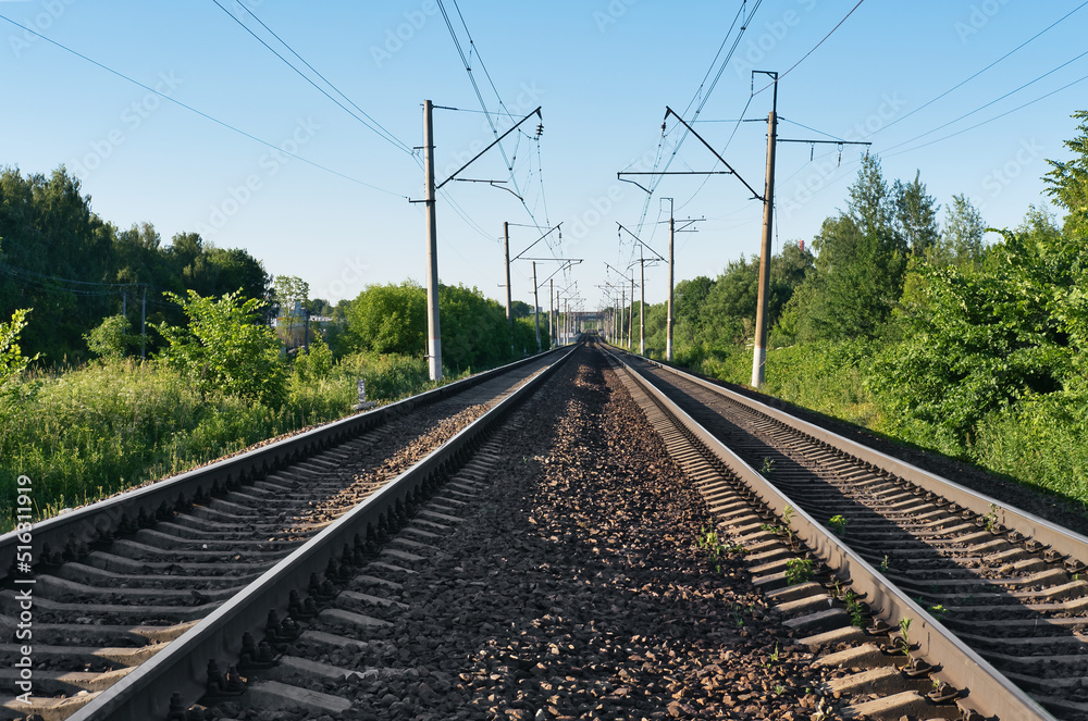 Two railway tracks at summer sunny day. Two railroad lines among the forest. Travel concept.