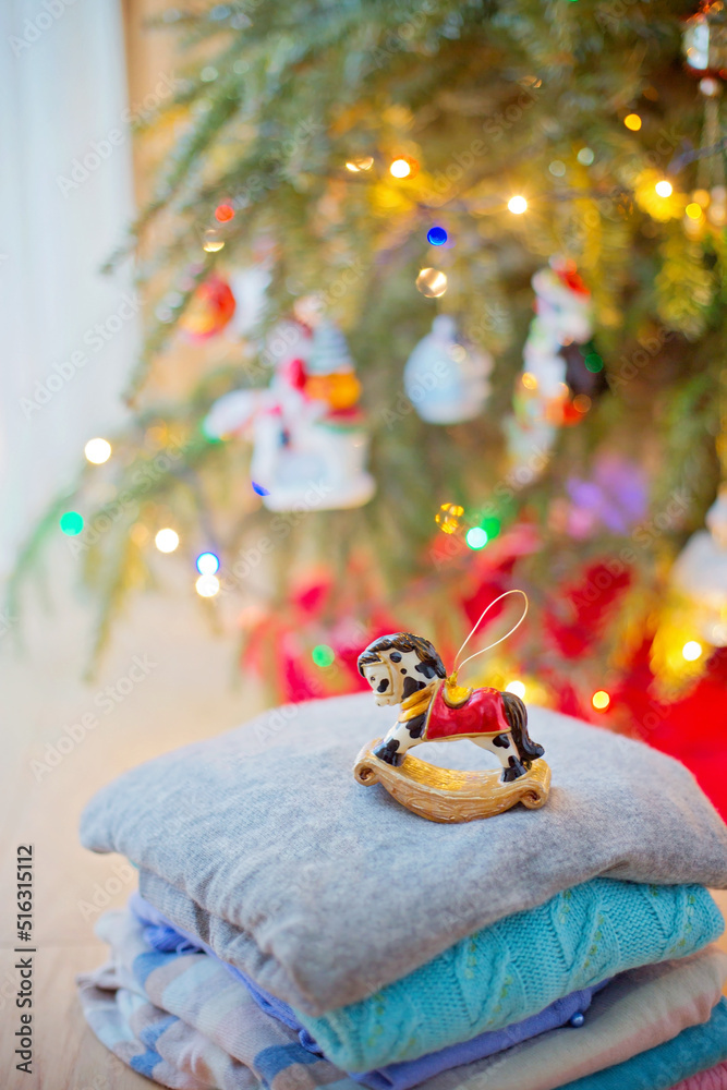 Christbaumschmuck Schaukelpferd mit Christbaum und Weihnachtsbeleuchtung im Hintergrund
