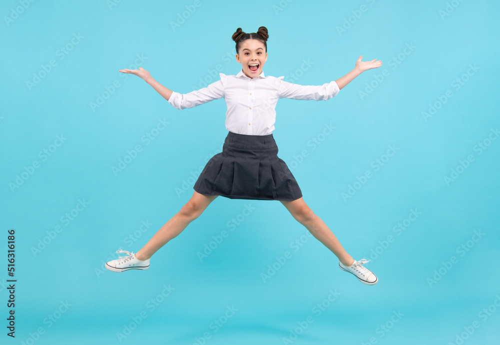 Full length cheerful teenager kid jump enjoy rejoice win isolated on blue background. Small child girl in summer dress jumping. Excited face. Amazed expression, cheerful and glad. Full length cheerful teenager kid jump enjoy rejoice win isolated on blue background. Small child girl in summer dress jumping. Excited face. Amazed expression, cheerful and glad.