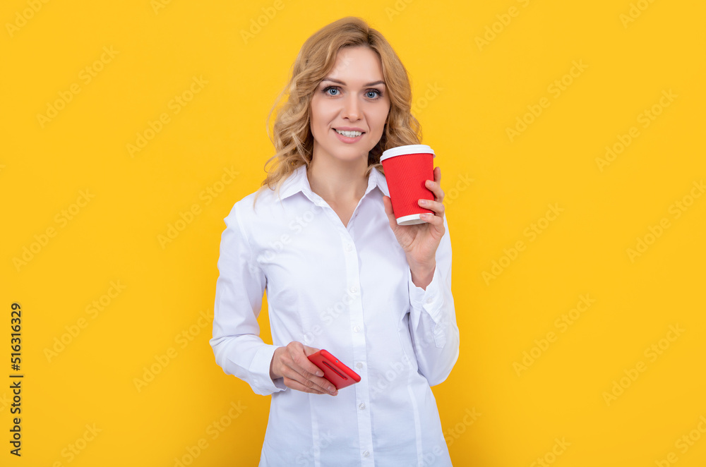 cheerful blonde woman with coffee cup and smartphone on yellow background cheerful blonde woman with coffee cup and smartphone on yellow background