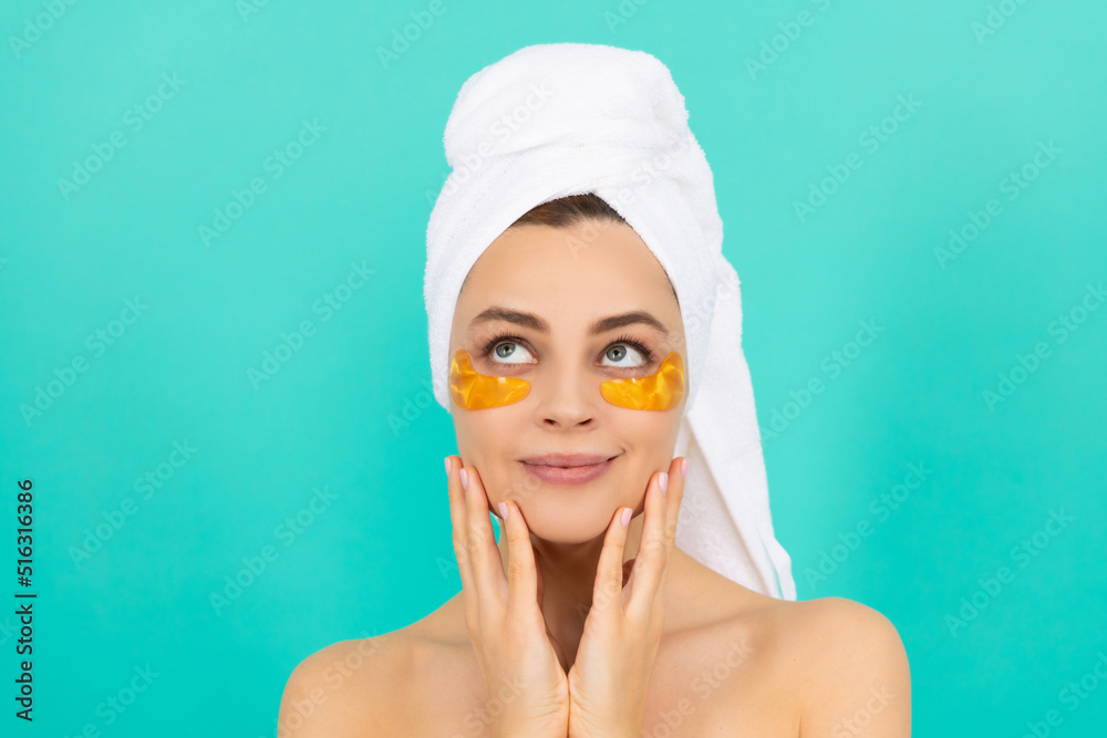 young woman smile has collagen gold eye patches on face with towel young woman smile has collagen gold eye patches on face with towel