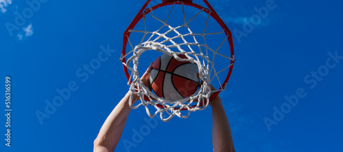 dunk in basket. slam dunk in motion. summer activity. smiling man with basketball ball. Horizontal poster design. Web banner header, copy space.