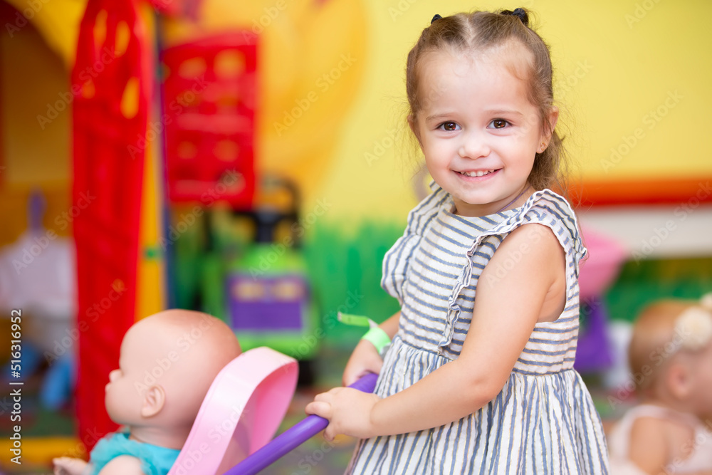 Little girl plays with a doll and smiles. Little girl plays with a doll and smiles.
