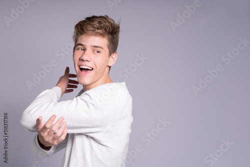 Portrait of handsome teenager guy hugging himself © watman