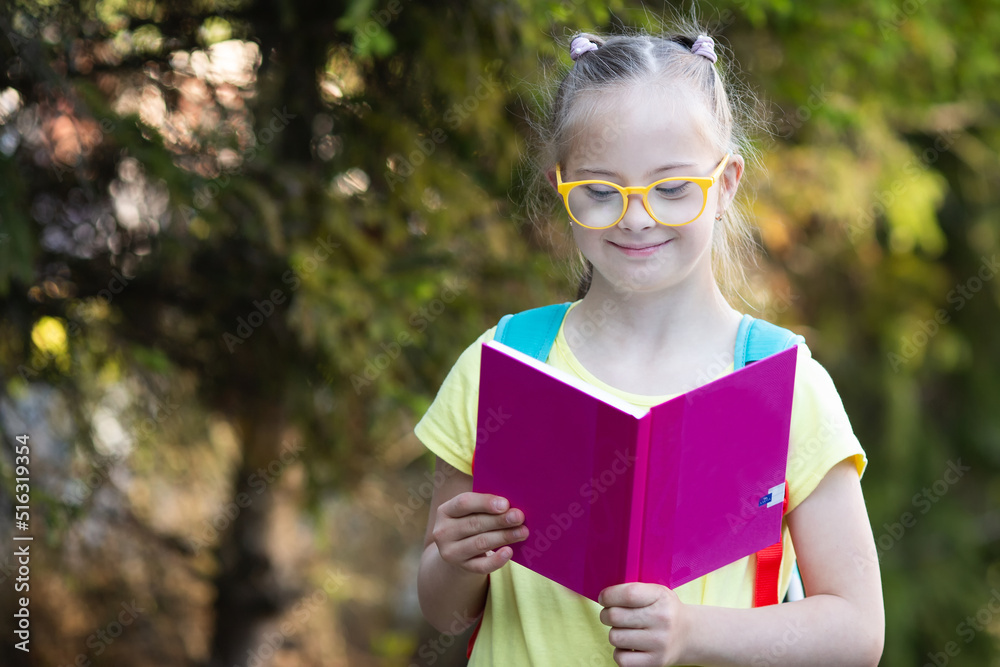 Fototapeta premium A girl with Down syndrome looks at the timetable