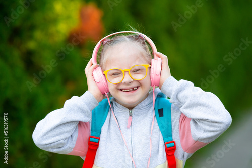 Girl with Down syndrome listens to music on her way to school photo