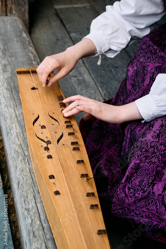 Fotografi Plying on the Norwegian traditional string instrument langeleik