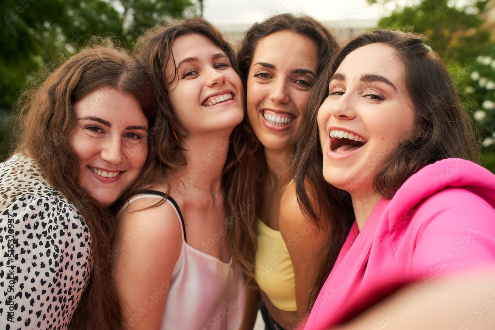 a group of four friends having fun and taking pictures of each other a group of four friends having fun and taking pictures of each other