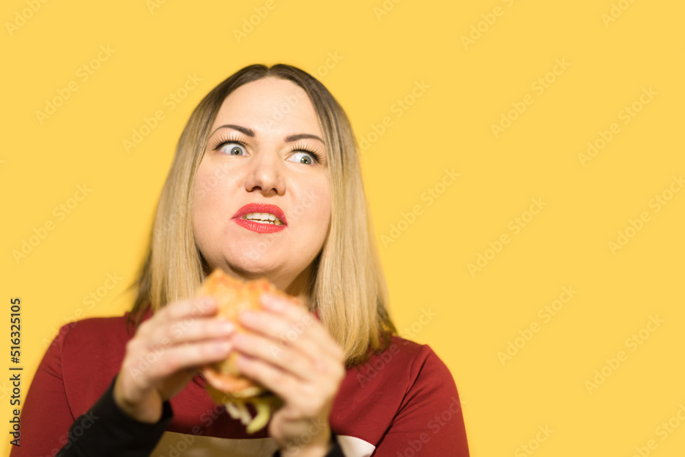 A hungry woman is biting a big tasty burger A hungry woman is biting a big tasty burger