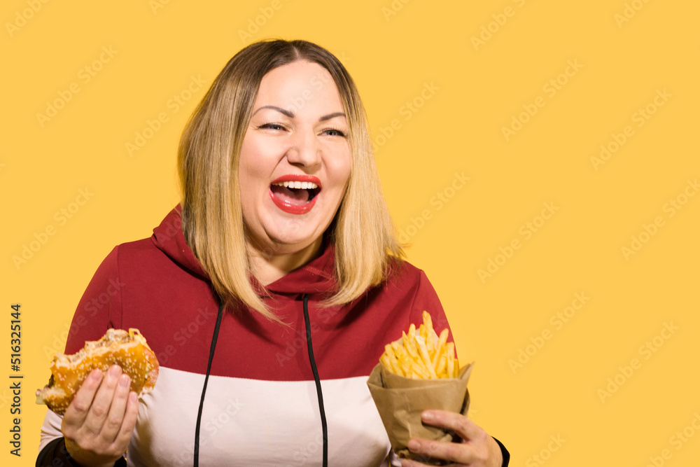 Body positive A hungry woman is biting a big tasty burger Body positive A hungry woman is biting a big tasty burger