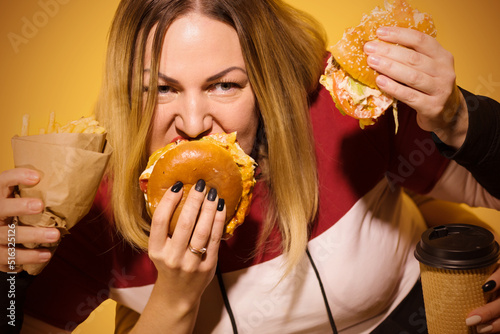 Body positive Woman with four hands eating fast food.