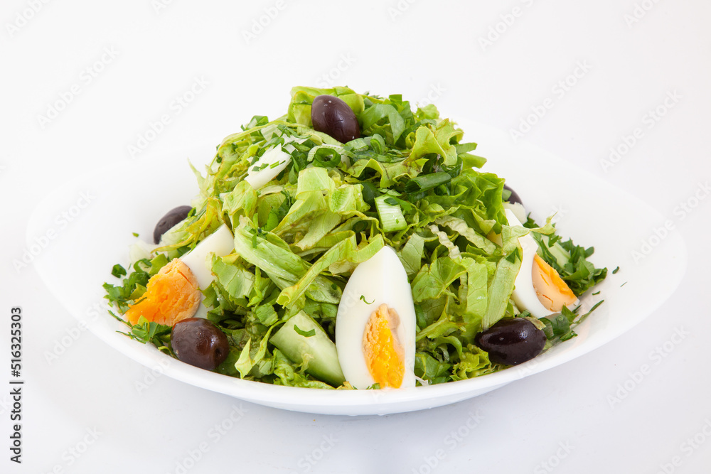 Fresh mixed green salad with eggs, avocado, olives and cucumbers. Delicious healthy food