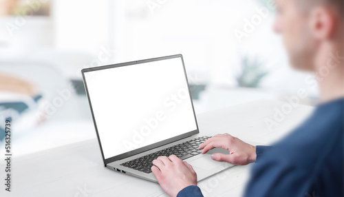 Mockup image of a man working at the laptop. Clean desk with office interior in background. Isolated screen in white for web page promotion