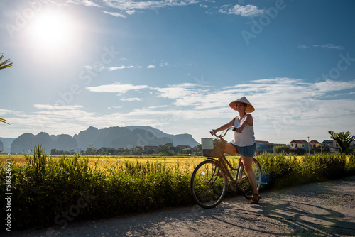 Mujer ciclista paseando por los arrozales de Ninh Binh, en Vietnam