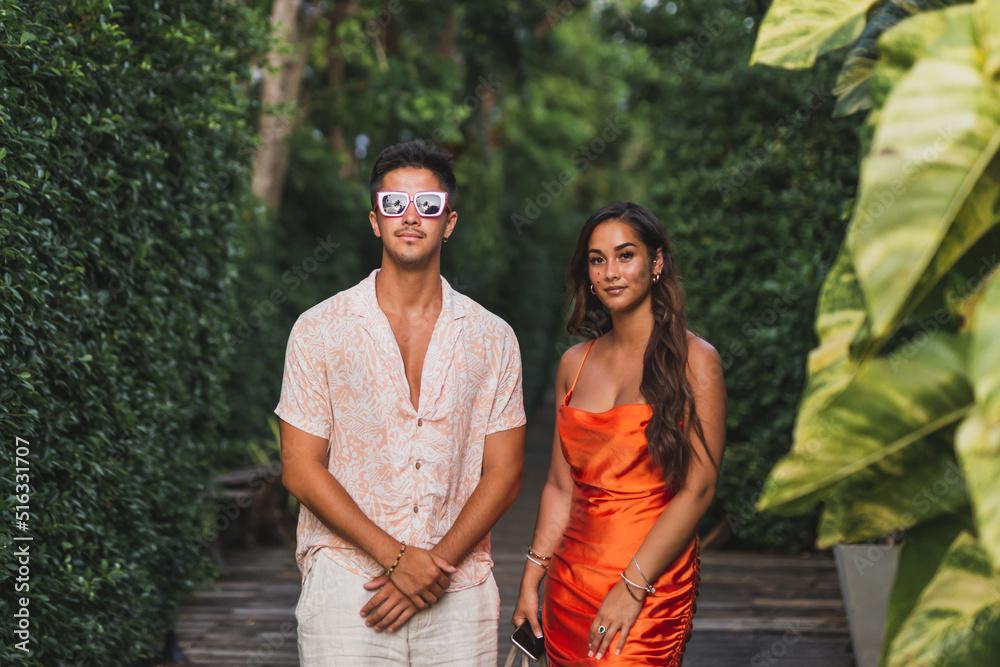 Fashion shot of an attractive young couple in summer clothes posing outdoor.