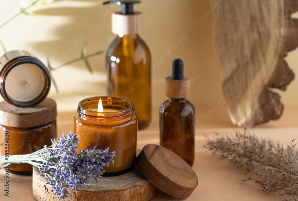 Soy candles in a glass jar. Aromatherapy. Burning candle and lavender. Wooden lid for jars. Beige background. Comfort and relaxation. Handmade. Home decor. Soy candles in a glass jar. Aromatherapy. Burning candle and lavender. Wooden lid for jars. Beige background. Comfort and relaxation. Handmade. Home decor.